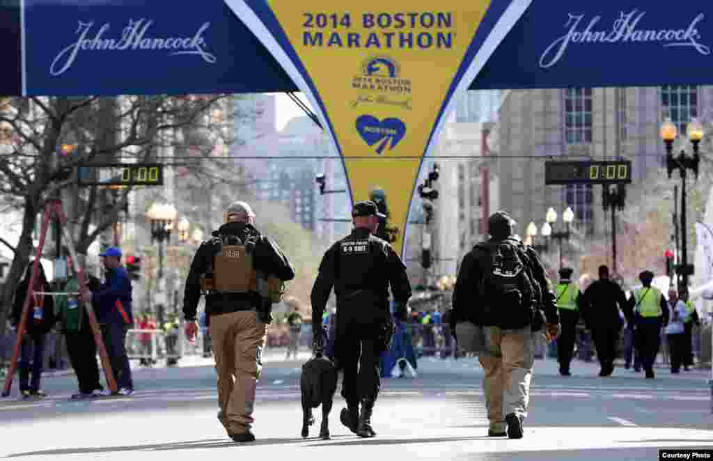 Apr 21, 2014; Boston, MA, USA; Boston police officers part of the K-9 unit patrol Boylston Street near the finish line before the start of the 2014 Boston Marathon. Mandatory Credit: Greg M. Cooper-USA TODAY Sports - RTR3M2SC