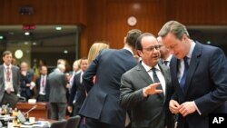 British Prime Minister David Cameron, right, speaks with French President Francois Hollande during a round table meeting at an EU summit in Brussels on Tuesday, June 28, 2016.