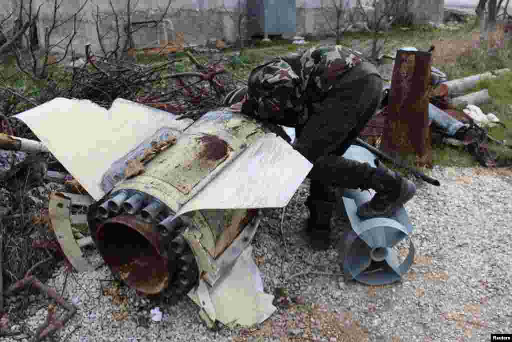 A Free Syrian Army fighter inspects an unexploded shell in Jabal al-Akrad area in Syria's northwestern Latakia province, Jan. 19, 2014. 