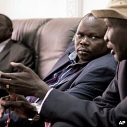 Pagan Amum, Chief Negotiator of the southern Sudan People's Liberation Movement (L), listens to remarks by Stephen Dhieu Dau, Minister of Petroleum and Mining in South Sudan, at Paloich Airport in Melut, South Sudan, February 21, 2012