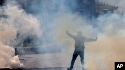 پولیس کی طرف سے مظاہرین کو منتشر کرنے کے لیے آنسو گیس کا استعمال بھی کیا گیا۔ (فائل فوٹو)