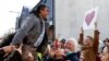Abdul Aziz yang selamat dari penembakan masjid diangkat tinggi-tinggi saat ia mengucapkan terima kasih kepada para pendukungnya di luar Pengadilan Tinggi Christchurch di Christchurch, Selandia Baru pada 27 Agustus 2020. (Foto: AP)