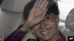 Burma's pro-democracy leader Aung San Suu Kyi greets migrant workers from Burma as she visits them in Samut Sakhon province, Thailand, May 30, 2012. 