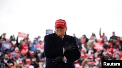 U.S. President Donald Trump reacts to cold weather and wind during a campaign rally at Michigan Sports Stars Park in Washington, Michigan, Nov. 1, 2020. 