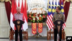 In this photo released by Indonesian Presidential Palace, Malaysian Prime Minister Ismail Sabri Yaakob, left, speaks as Indonesian President Joko Widodo looks on during a press conference following their meeting at Merdeka Palace in Jakarta, Indonesia, Friday, April 1, 2022. 