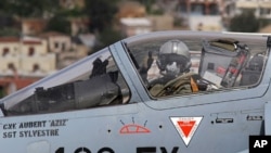 A French pilot gives a thumbs-up before taking off in a Mirage 2000 fighter jet from the Greek air base at Souda on the island of Crete, March 30, 2011