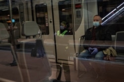 Commuters wearing face masks to protect against coronavirus at Atocha train station in Madrid, Spain, April 13, 2020.