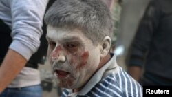 An injured man reacts at a site hit by airstrikes in the rebel-held area of Aleppo's Bustan al-Qasr, Syria, April 29, 2016.