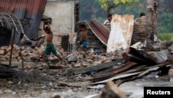 FILE - Children recycle goods from the ruins of a market which was set on fire at a Rohingya village outside Maugndaw in Rakhine state, Myanmar, Oct. 27, 2016. 