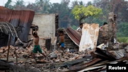 Children recycle goods from the ruins of a market which was set on fire at a Rohingya village outside Maugndaw in Rakhine state, Myanmar, Oct. 27, 2016. 