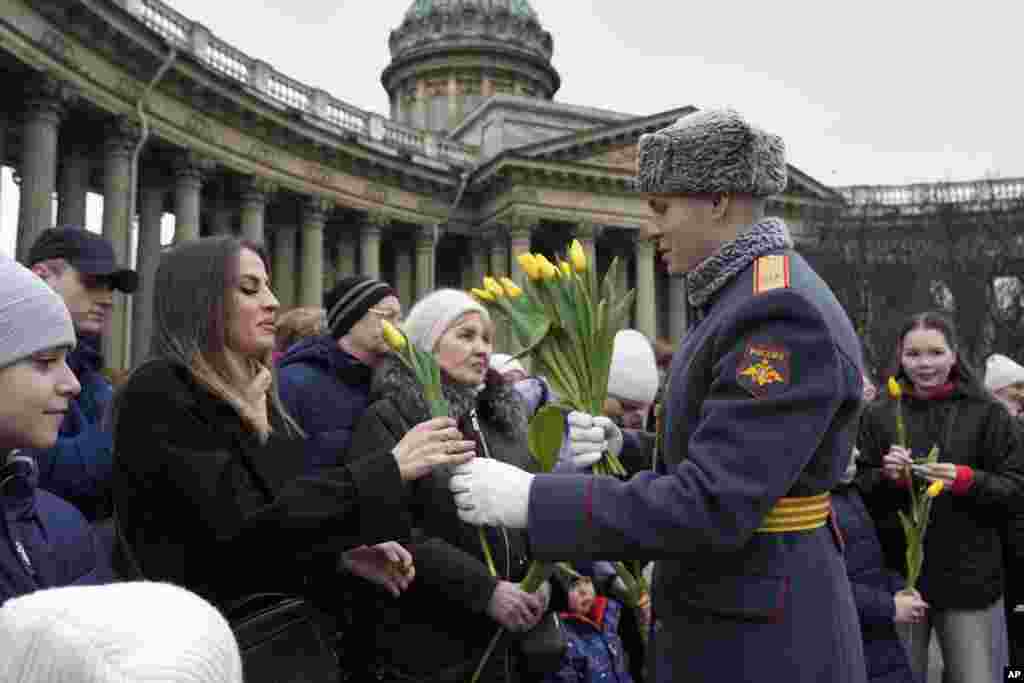 Un soldado de la guardia de honor entrega flores a las mujeres durante la celebración del Día Internacional de la Mujer en San Petersburgo, Rusia, el sábado 8 de marzo de 2025. (Foto AP/Dmitri Lovetsky)