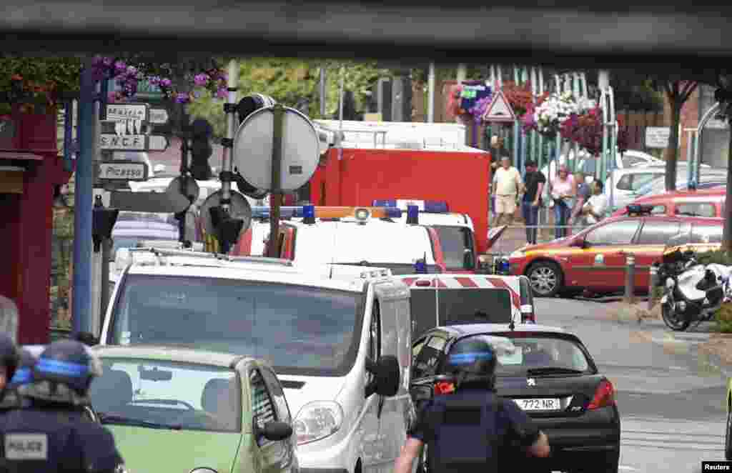 Police and rescue workers stand at the scene after two assailants had taken five people hostage in the church at Saint-Etienne-du -Rouvray near Rouen in Normandy, France on July 26, 2016.