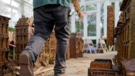 A worker walks around miniature (very small) New York City landmarks during the preparations for the annual Holiday Train Show at the New York Botanical Garden in New York, November 11, 2021.