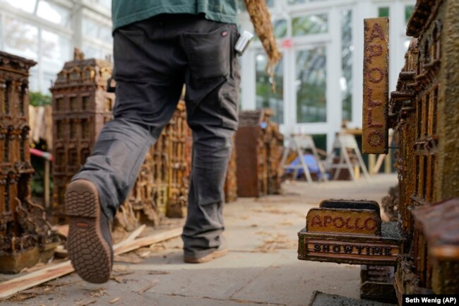 A worker walks around miniature (very small) New York City landmarks during the preparations for the annual Holiday Train Show at the New York Botanical Garden in New York, November 11, 2021.