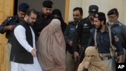 Pakistani officials escort famed Afghan woman Sharbat Gulla in a burqa or veil outside a court in Peshawar, Pakistan, Nov. 4, 2016. 