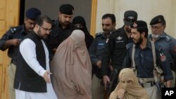 Pakistani officials escort famed Afghan woman Sharbat Gulla in a burqa or veil outside a court in Peshawar, Nov. 4, 2016. 