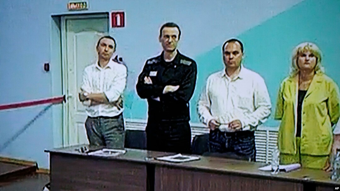 Lãnh đạo phe đối lập Nga Alexei Navalny (thứ 2, bên trái) được nhìn thấy trên màn hình TV đứng giữa các luật sư của mình khi ông xuất hiện trong phiên xử tại trại giam ở Melekhovo, Nga, vào ngày 4/8/2023.