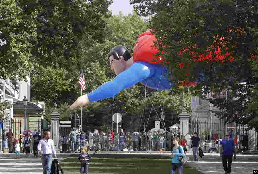 A giant inflatable Superman flies past the U.S. embassy during the Balloon Day Parade in Brussels, Belgium.