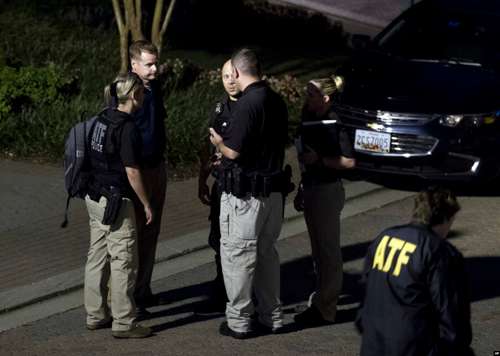 Agentes de la Oficina de Alcohol, Tabaco, Armas de Fuego y Explosivos salen de la casa en Baltimore, Maryland, del sospechoso del tirotoe en Jakcsonville, Florida, el domingo, 26 de agosto de 2018.