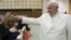 Pope Francis blesses a child during a special audience with Vatican employees for Christmas greetings at the Paul VI hall at the Vatican, Dec. 21, 2015.