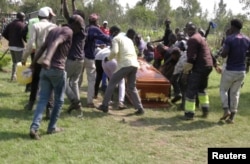 FILE - Mourners and fans of Kenyan musician Bernard Obonyo, whose stage name is Abenny Jachiga, carry his coffin away as they proceed his burial under the rules for the suspected COVID-19 cases, at Chiga village near Kisumu, Kenya, June 12, 2020.