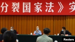 中国全国人大委员长栗战书（右）中央军委副主席许其亮（中）在北京出席“反分裂国家法”会议。（2020年5月29日）