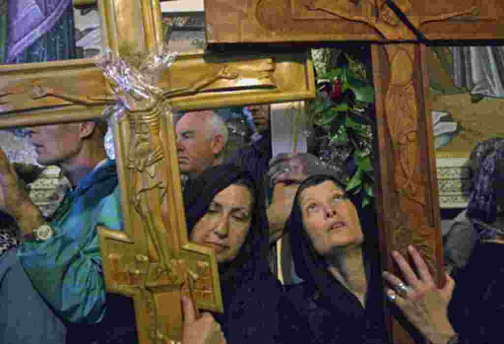 Christians carry crosses inside the Church of the Holy Sepulcher during a Good Friday procession in Jerusalem's Old City, Apr 22 2011