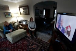 Lally Doerrer, right, and Katharine Hildebrand watch Joe Biden during his Illinois virtual town hall, in Doerrer's living room March 13, 2020, in Chicago.