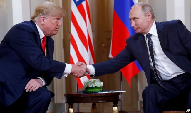 FILE - In this Monday, July 16, 2018, file photo, U.S. President Donald Trump, left, and Russian President Vladimir Putin shake hands at the beginning of a meeting at the Presidential Palace in Helsinki, Finland.