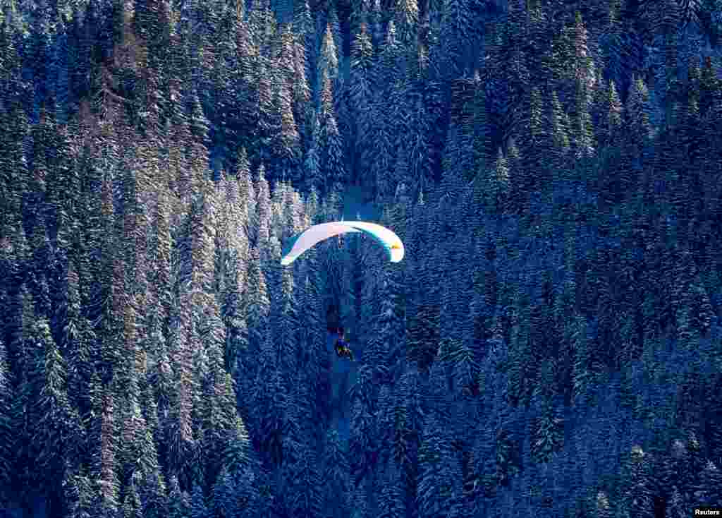 Seorang paraglider terlihat setelah hujan salju lebat melanda kota Werfenweng, Austria.