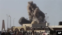 Anti-Gadhafi rebels run away as smoke rises following an air strike by Libyan warplanes near a checkpoint of the anti-Libyan Leader Moammar Gadhafi rebels, in the oil town of Ras Lanouf, eastern Libya, March 7, 2011