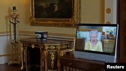 La reina Isabel de Inglaterra aparece en una pantalla a través de un enlace de video desde el castillo de Windsor, durante una audiencia virtual para recibir al embajador de la República de Corea, Gunn Kim, en el Palacio de Buckingham, Londres, el 26 de octubre de 2021.