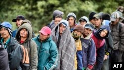 FILE - Migrants wait to receive food donated by the Community Center for Migrant Assistance in the municipality of Caborca in Sonora state, Mexico, Jan. 13, 2017.