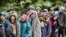 FILE - Migrants wait to receive food donated by the Community Center for Migrant Assistance in the municipality of Caborca in Sonora state, Mexico, Jan. 13, 2017.