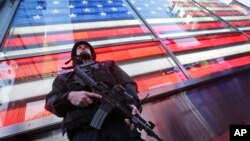 FILE - A heavily armed New York city police officer with the Strategic Response Group stands guard in New York's Times Square, Nov. 14, 2015. 