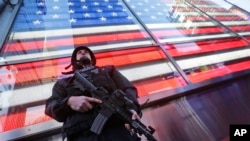 FILE - A heavily armed New York city police officer with the Strategic Response Group stands guard at New York's Times Square, Nov. 14, 2015.