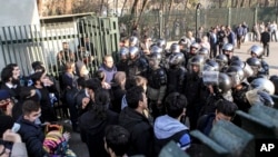 In this photo taken by an individual not employed by the Associated Press and obtained by the AP outside Iran, anti-riot Iranian police prevent university students to join other protesters over Iran weak economy, in Tehran, Iran, Saturday, Dec. 30, 2017.