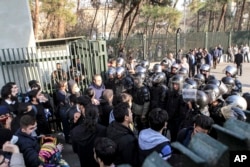 FILE - In this photo taken by an individual not employed by the Associated Press and obtained by the AP outside Iran, anti-riot Iranian police prevent university students to join other protesters, in Tehran, Iran, Dec. 30, 2017.