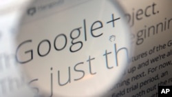 FILE: A computer monitor in Berlin displays information about Google+ service, seen through a magnifying glass.