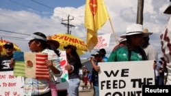 Dos niñas sostienen carteles mientras latinos en Florida, junto con personas negras, indígenas y otros aliados, protestan contra el proyecto de ley SB 1718, en Immokalee, Florida el 1 de junio de 2023.