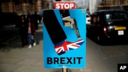 Placards placed by anti-Brexit supporters stand opposite the Houses of Parliament in London, March 18, 2019.