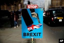Brexit placards placed by anti-Brexit supporters stand opposite the Houses of Parliament in London, March 18, 2019.