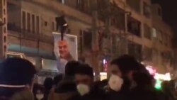 Protester pulls down Soleimani banner