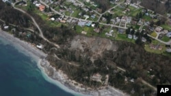 In this aerial photo, a landslide is shown near Coupeville, Wash. on Whidbey Island, Wednesday, March 27, 2013. Whidbey Island authorities say one home has been severely damaged by the landslide that has isolated or threatened 33 more homes in the community overlooking Puget Sound about 50 miles north of Seattle. Central Whidbey Fire and Rescue evacuated one person from the damaged home. About 10 more residents have been evacuated by boat. (AP Photo/Ted S. Warren)