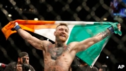 Conor McGregor réagit après avoir vaincu Jose Aldo lors d'un combat d'arts martiaux mixtes de championnat poids plume à l'UFC 194 à Las Vegas, le 12 décembre 2015.