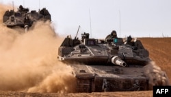 Israeli army battle tanks move near the border with the Gaza Strip at a location in southern Israel on May 13, 2024, amid the ongoing conflict in the Palestinian territory between Israel and the Hamas movement. 