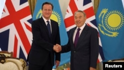 Presiden Kazakhstan Nursultan Nazarbayev (kanan) bersalaman dengan PM Inggris David Cameron dalam pertemuan di Astana, Kazakhstan hari Senin (1/7). 