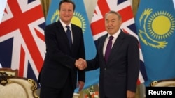 Kazakhstan's President Nursultan Nazarbayev (R) shakes hands with Britain's Prime Minister David Cameron during a meeting in Astana, Kazakhstan, July 1, 2013.