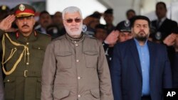 FILE - Abu Mahdi al-Muhindis, center, Deputy Chairman of al-Hashd al-Shaabi, an Iraqi Shiite militia, attends a ceremony marking Police Day at the police academy in Baghdad, Iraq, Jan. 9, 2016. 