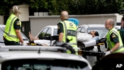 Ambulance staff take a man from outside a mosque in central Christchurch, New Zealand, March 15, 2019. A witness says many people have been killed in a mass shooting at a mosque in the New Zealand city of Christchurch.